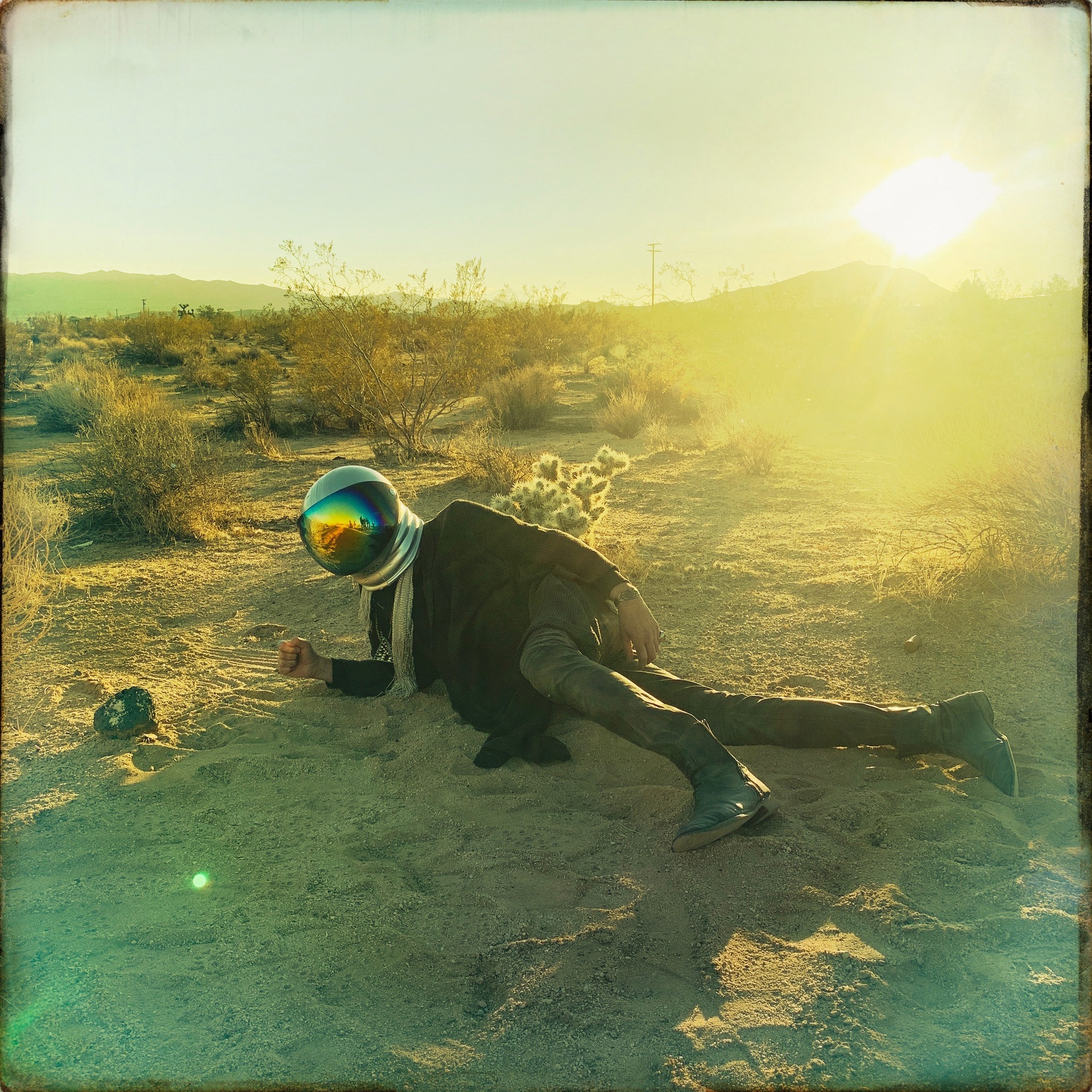Man in a Space helmet laying in the desert